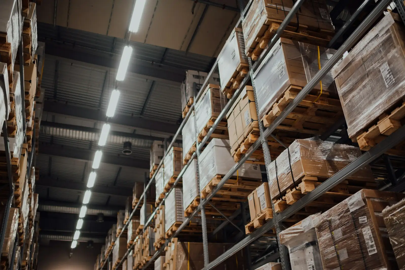 Cartons on pallets stacked high on warehouse racks.