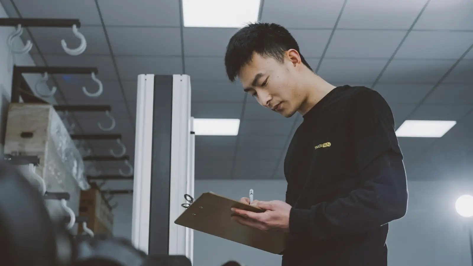 A warehouse worker checking items against a clipboard.